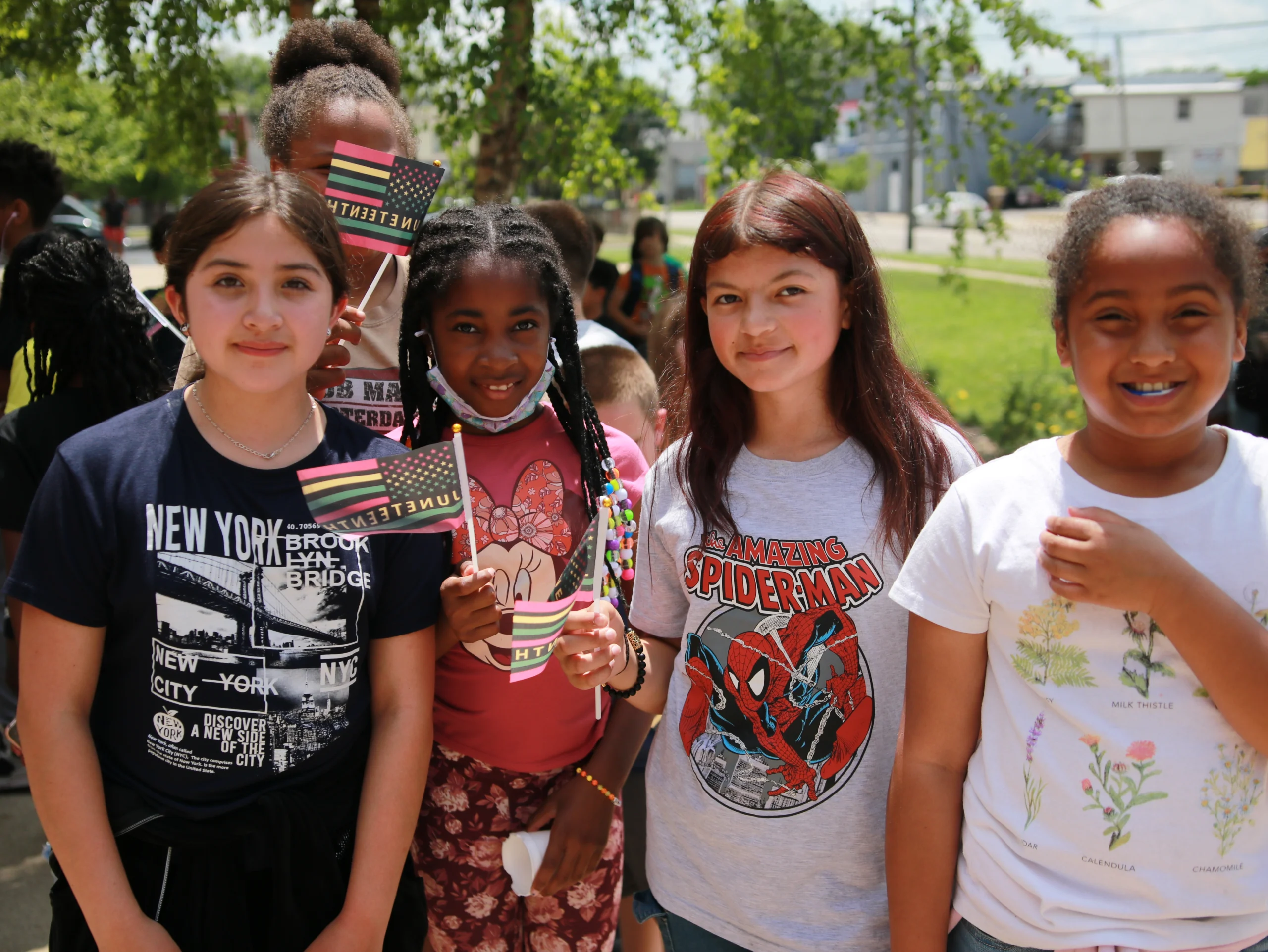 Img 1162 Smiling Club members outdoors holding Juneteenth flags