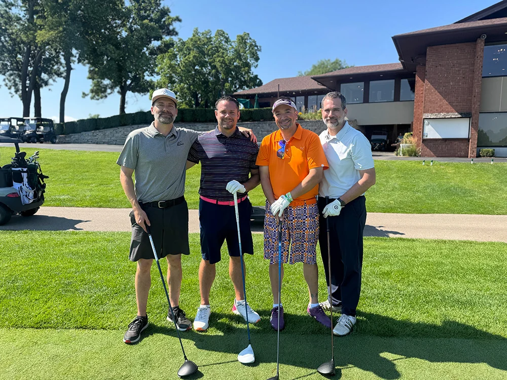 2026 Golf Outing Four golfers holding their drivers on the tee box