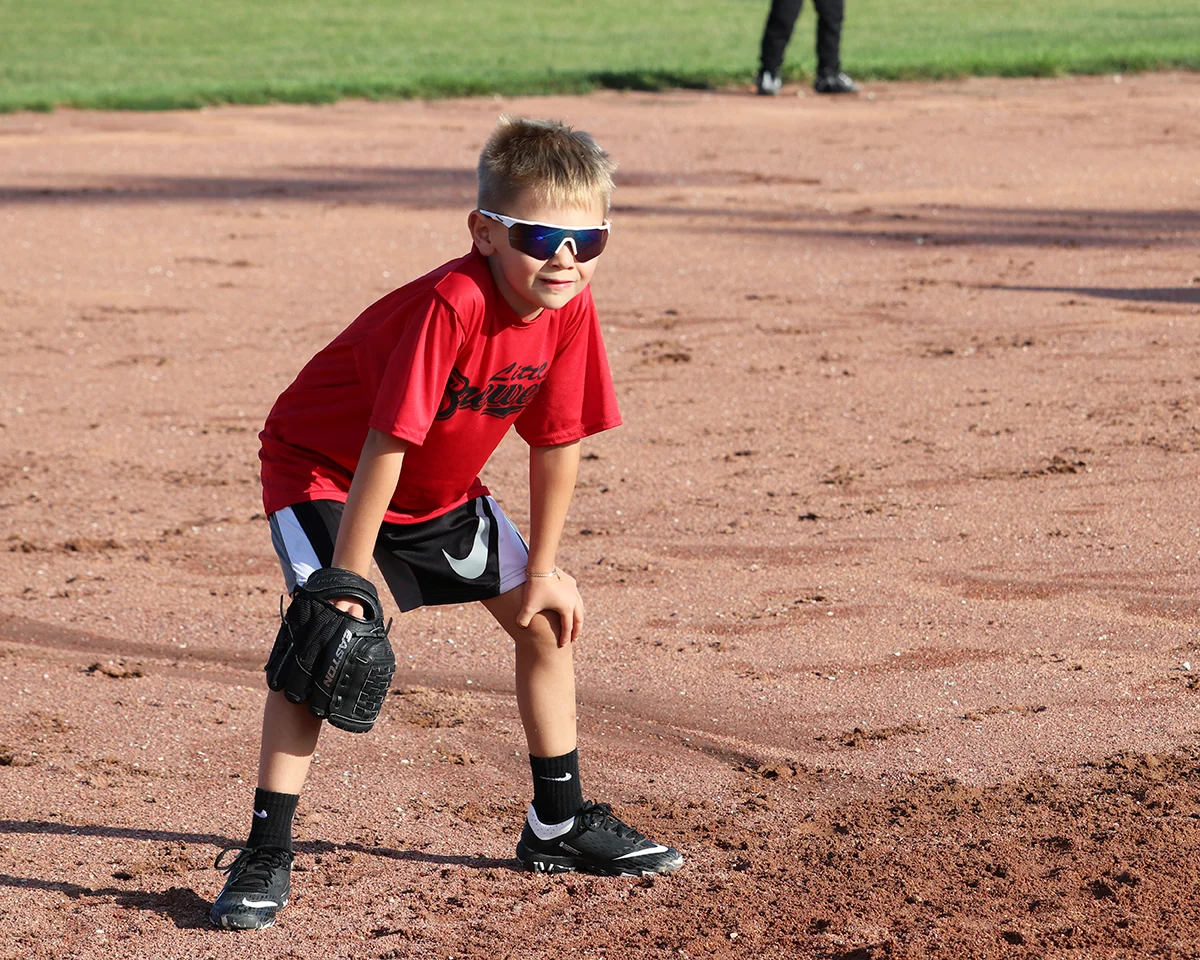 A young baseball player crouched and ready in the infield